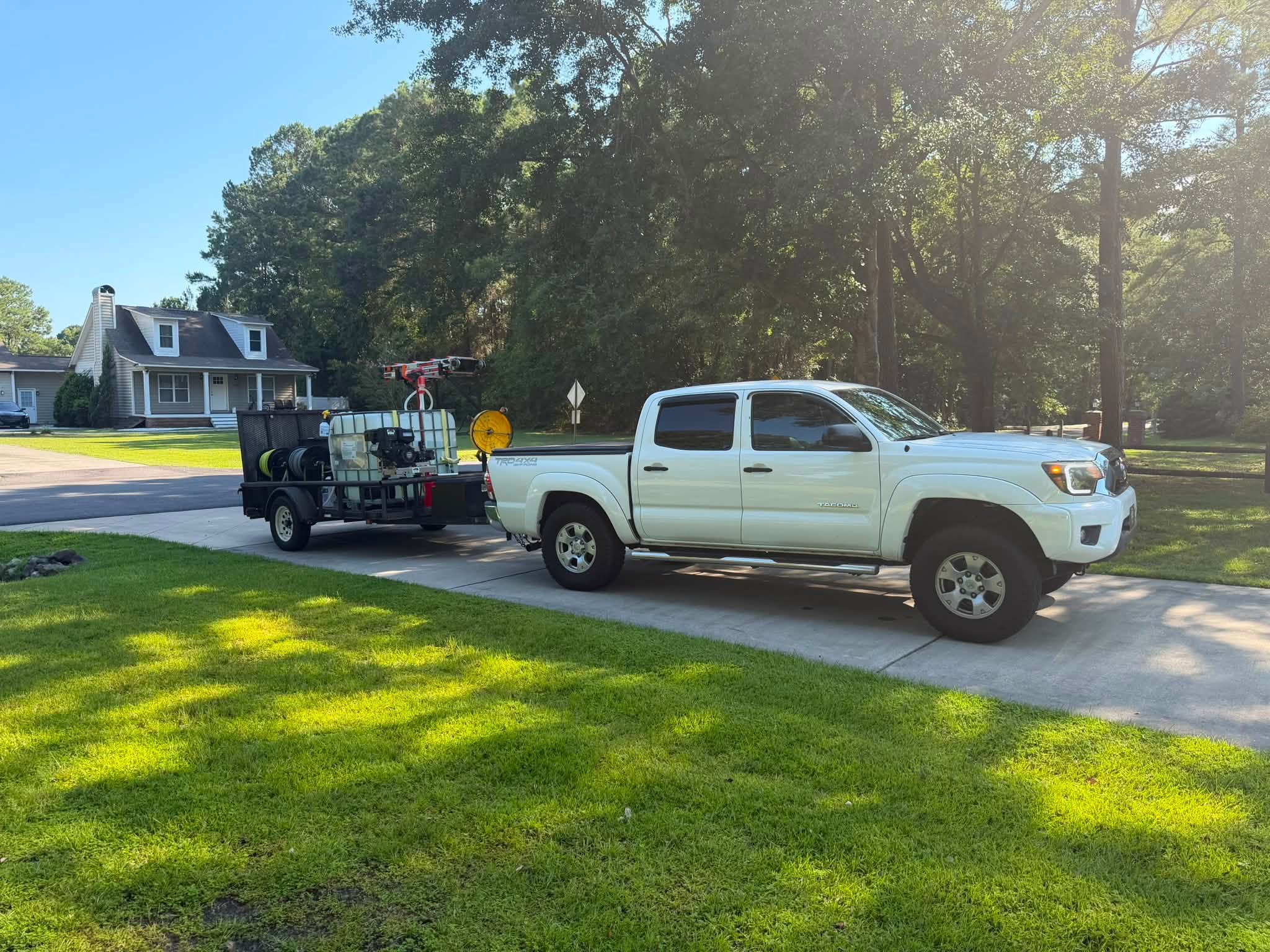 On Edge Lawn Care truck and equipment trailer on a freshly cut lawn